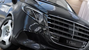 Close-up of the front of a black Mercedes V-Class, showcasing the grille and headlights, symbolizing elegance and luxury.